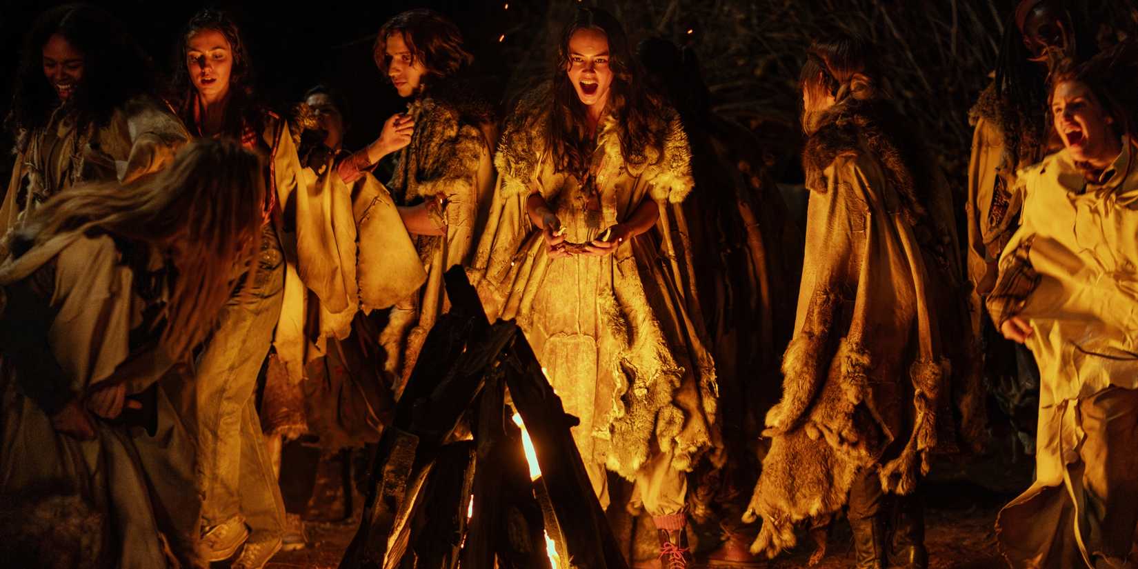 young lottie and the other teen yellowjackets girls dancing around a fire during the feast of coach ben