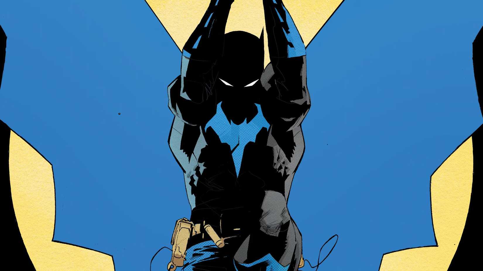 Batman, mostly covered in shadow, swinging out from a yellow light behind him.
