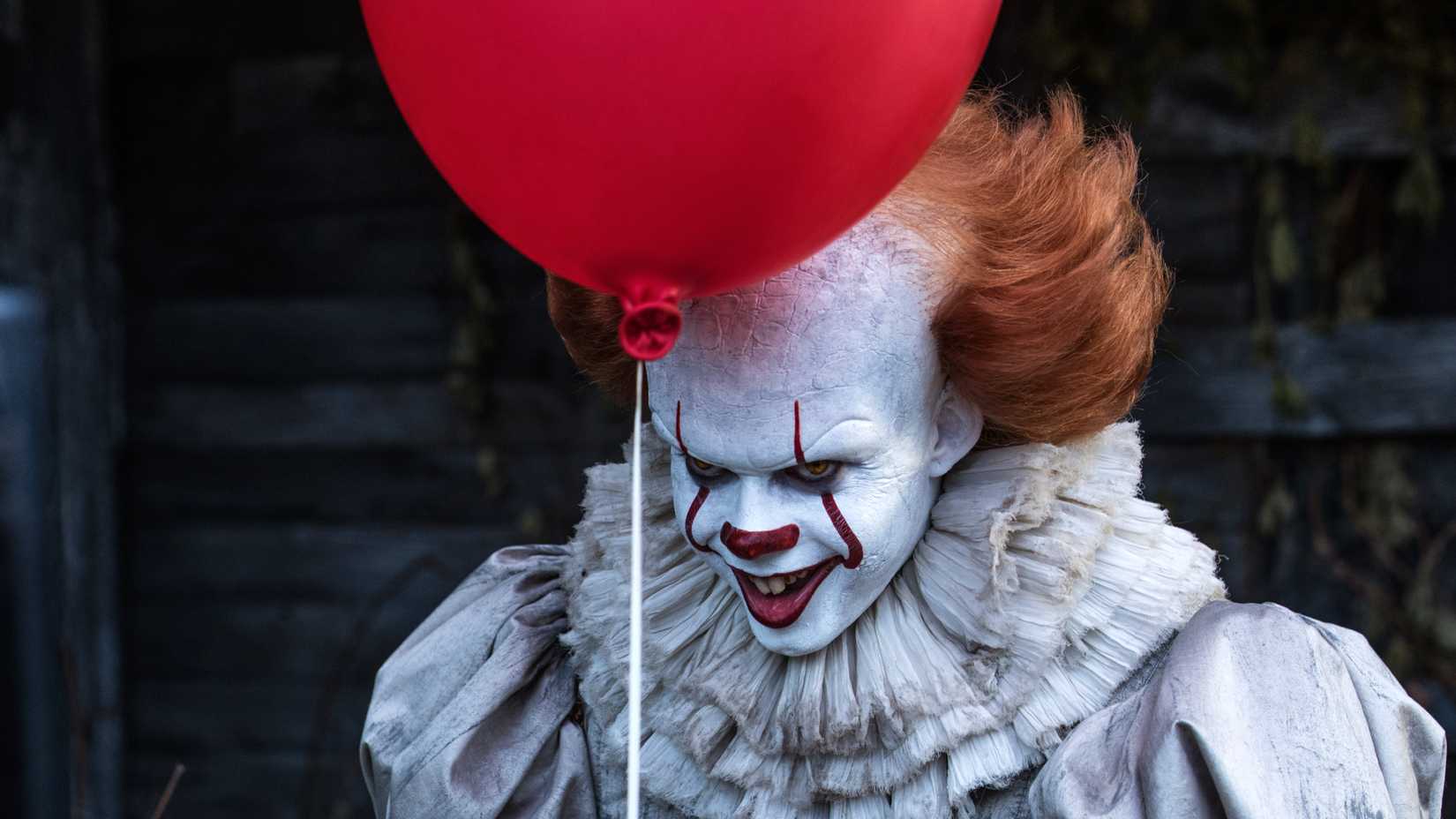 Bill Skarsgard as Pennywise with a red balloon in IT 2017