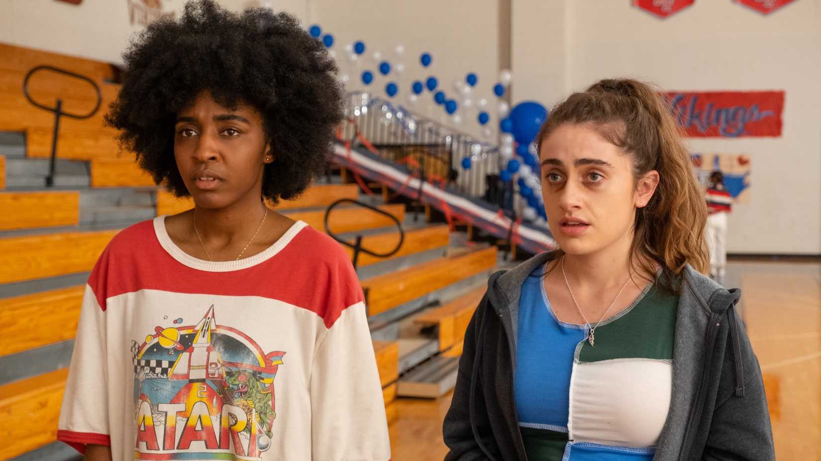 Ayo Edebiri and Rachel Sennott standing in a high school gymnasium in the 2023 film Bottoms.