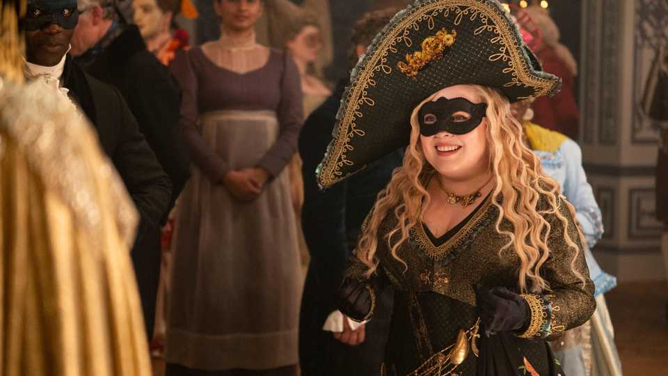 Bridgerton season 4 still featuring Penelope Feathrington in a black costume.