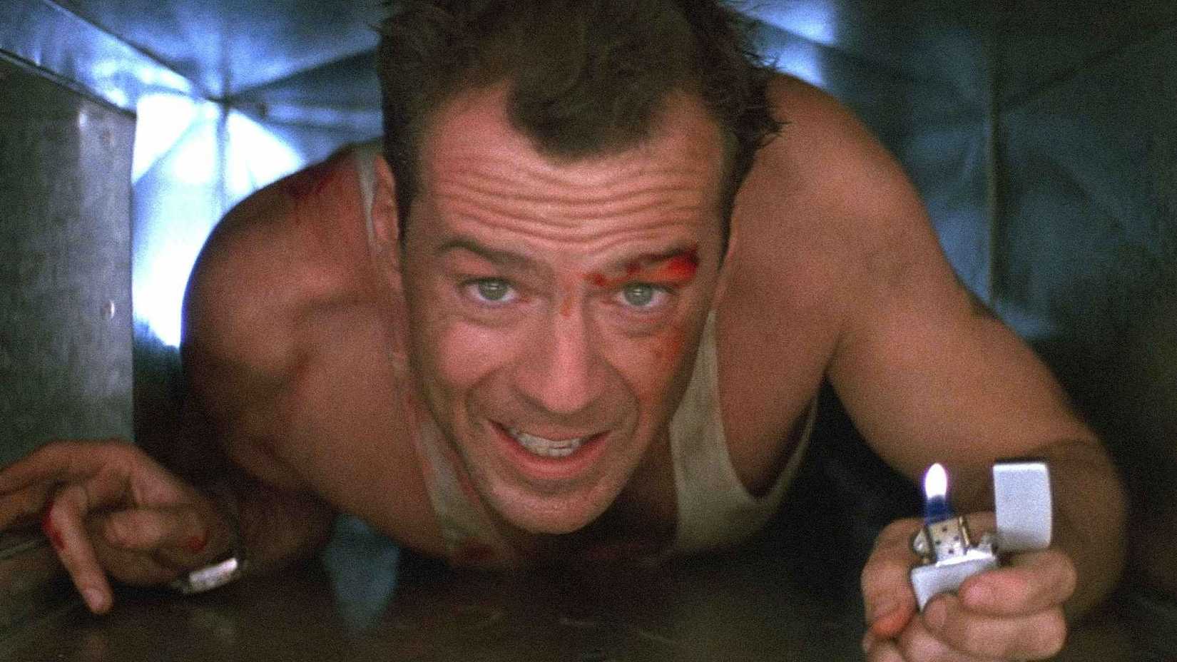Bruce Willis como John McClane rastejando pelos dutos de ar em Duro de Matar