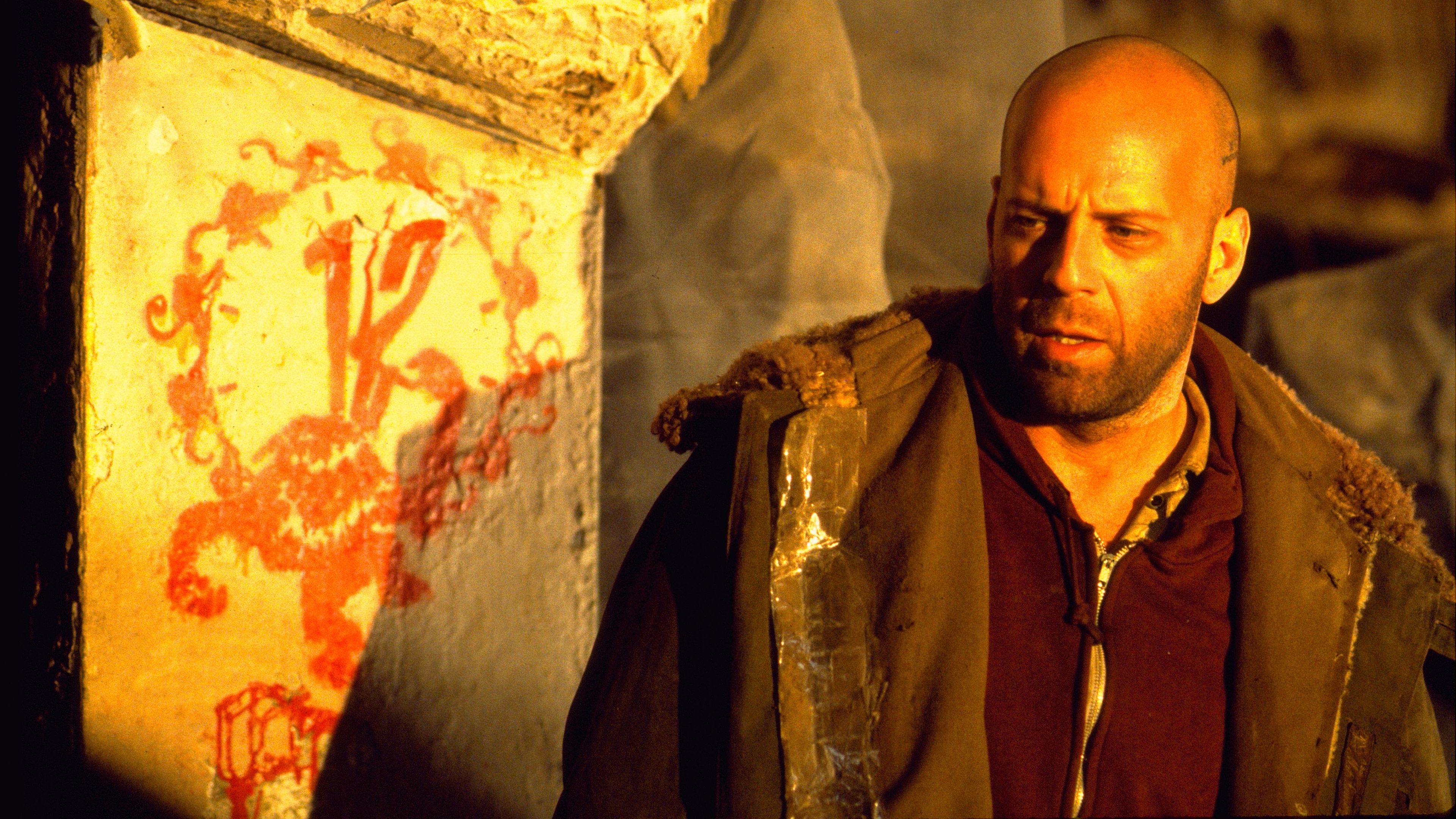 Bruce Willis' James Cole looking tired next to 12 Monkeys graffiti art