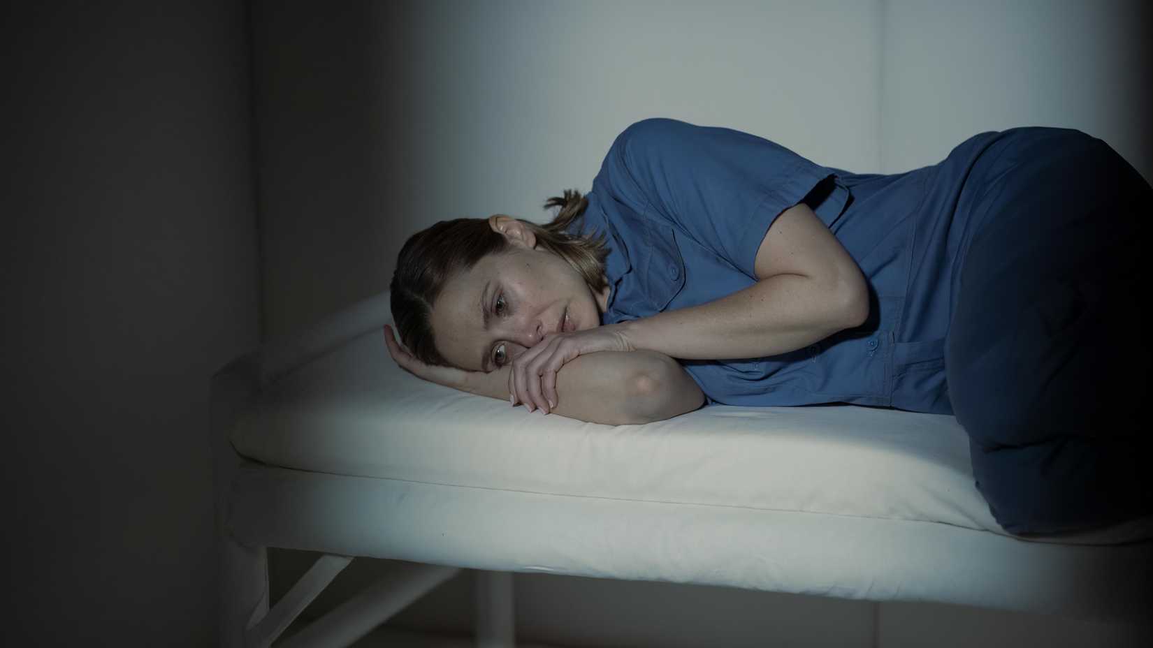 candy lying on a bed in a prison cell in love death