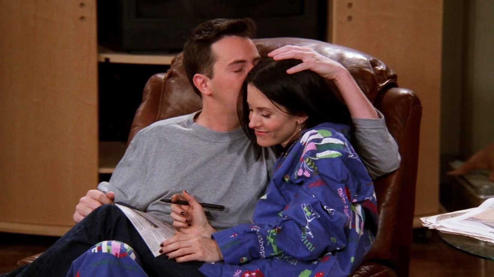 Chandler and Monica cuddling on the couch in Friends