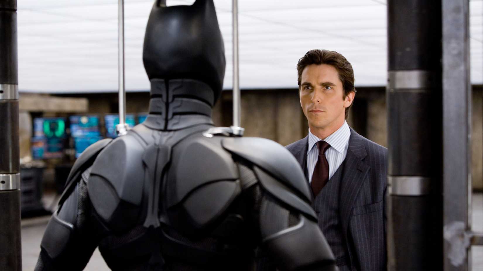 Christian Bale looking at his Batman suit in The Dark Knight