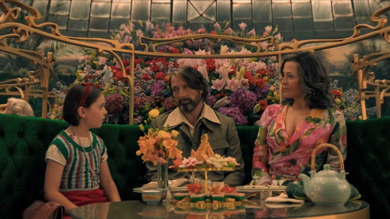 Aurora, Resident 5B, and Laverne have tea while surrounded by flowers in Dust Bunny (2025)