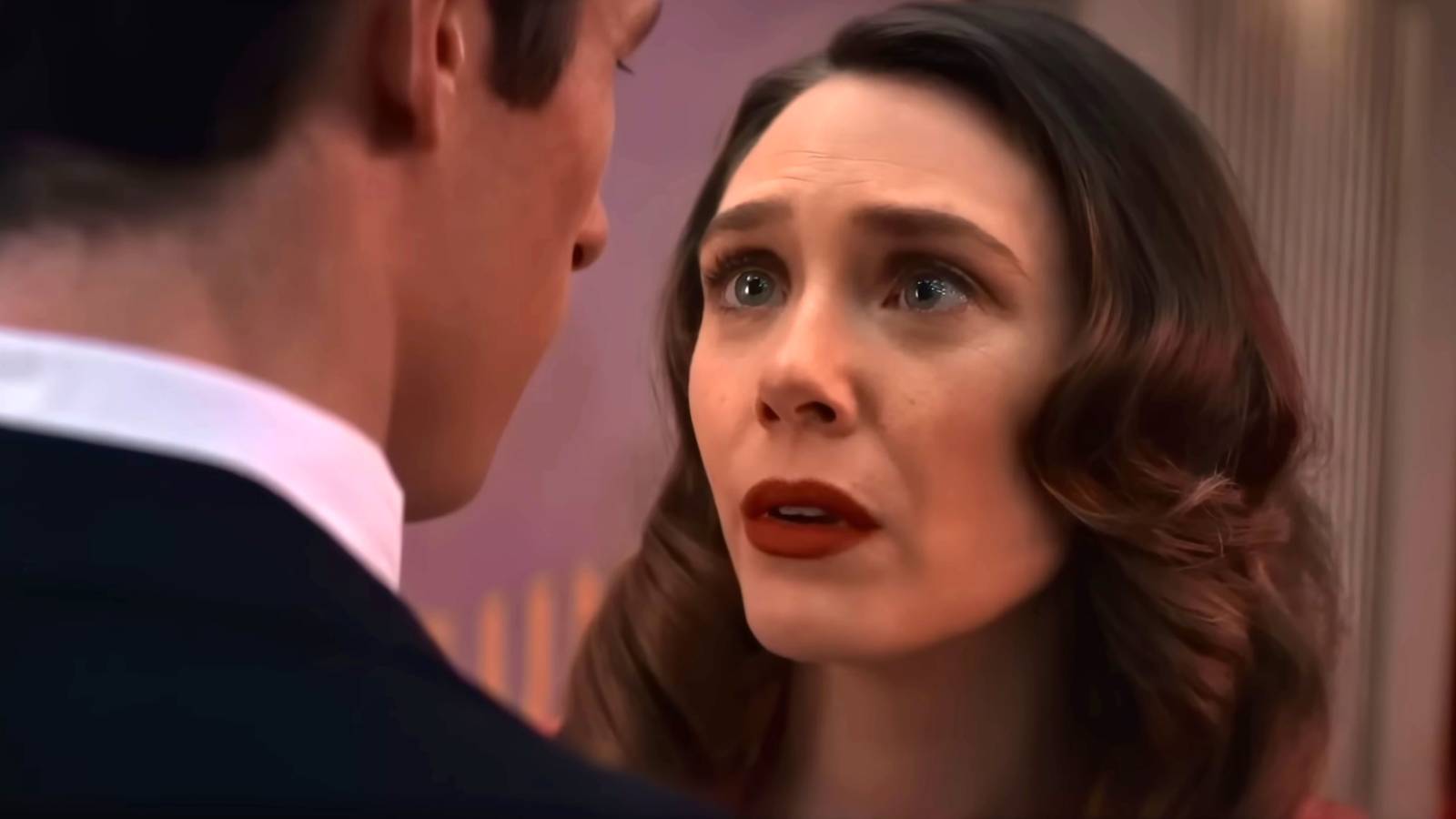 Elizabeth Olsen's Joan looking worriedly up toward Callum Turner's Luke in Eternity