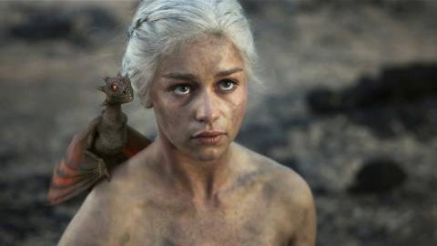 Emilia Clarke as Daenerys Targaryen with a baby dragon on her shoulder in Game of Thrones