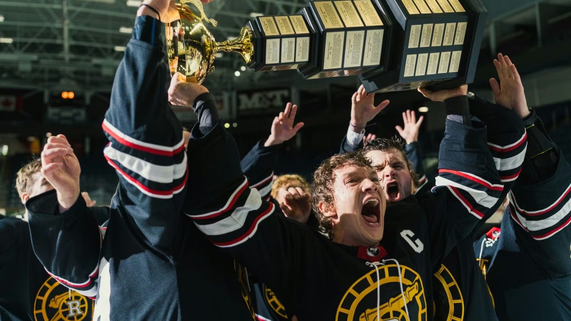 Una squadra di hockey esulta mentre Ilya Rozanov solleva una coppa in Heated Rivalry