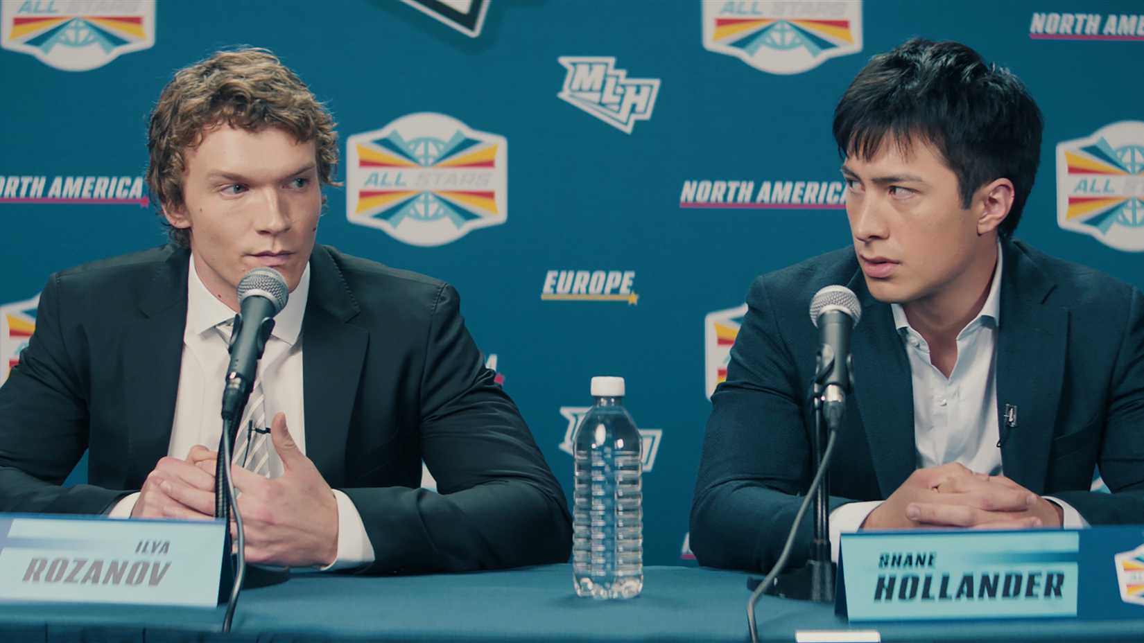 Ilya Rozanov (Connor Storrie) and Shane Hollander (Hudson Williams) at a press conference in Heated Rivalry.