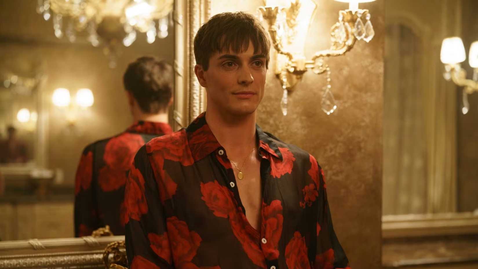 Kaden Connors wearing a black shirt with red roses as Sasha in Heated Rivalry.