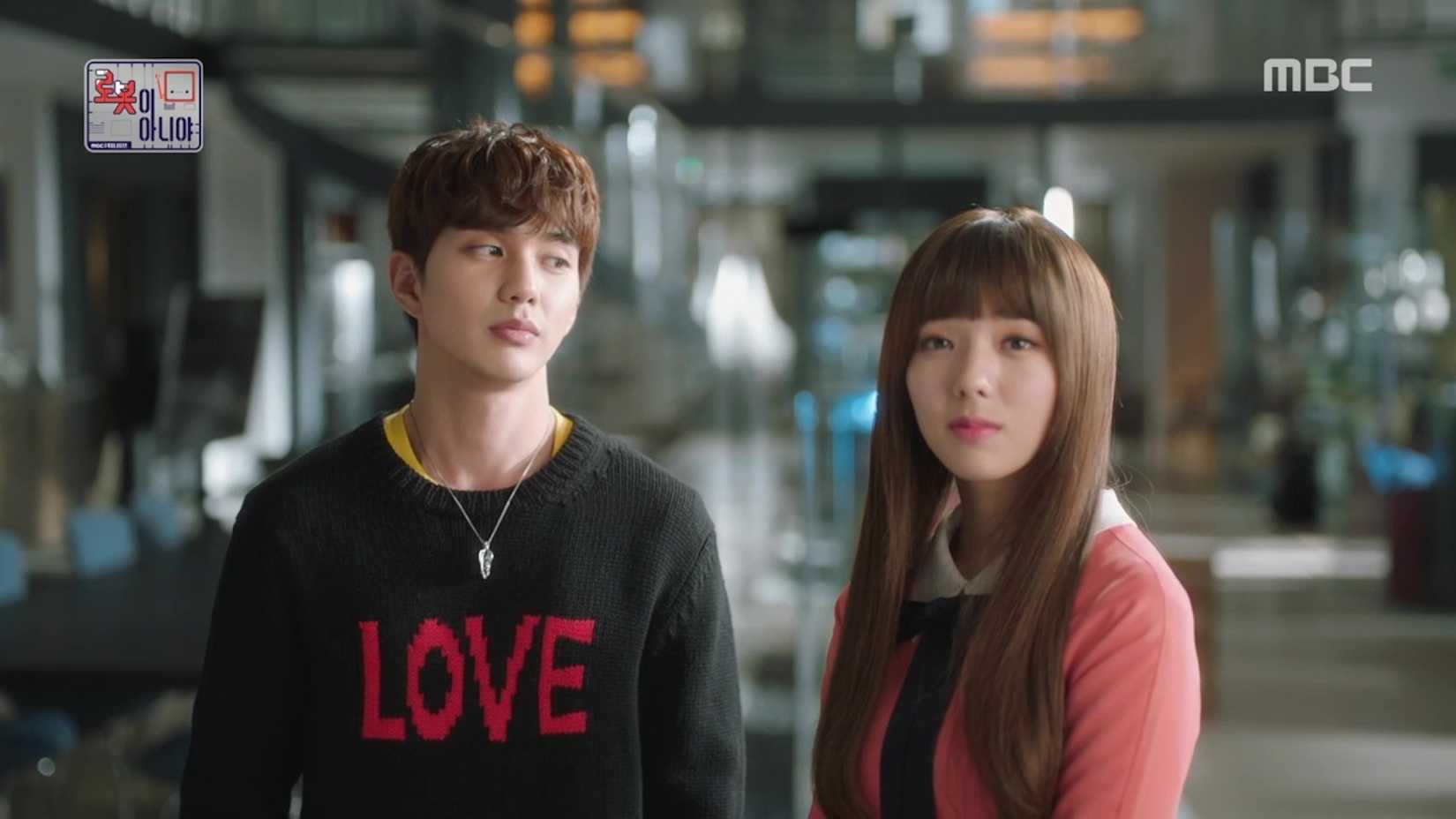 Kim Min-kyu (Yoo Seung-ho) wearing a sweater that says "love" while looking at Aji 3 (Chae Soo-bin).