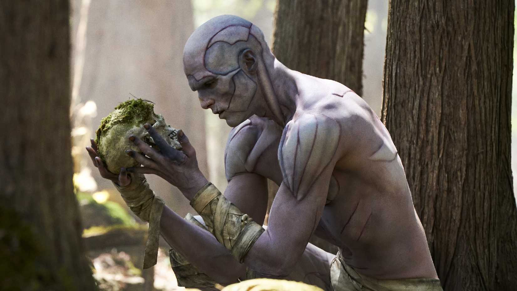 O Monstro de Jacob Elordi segurando um crânio em Frankenstein