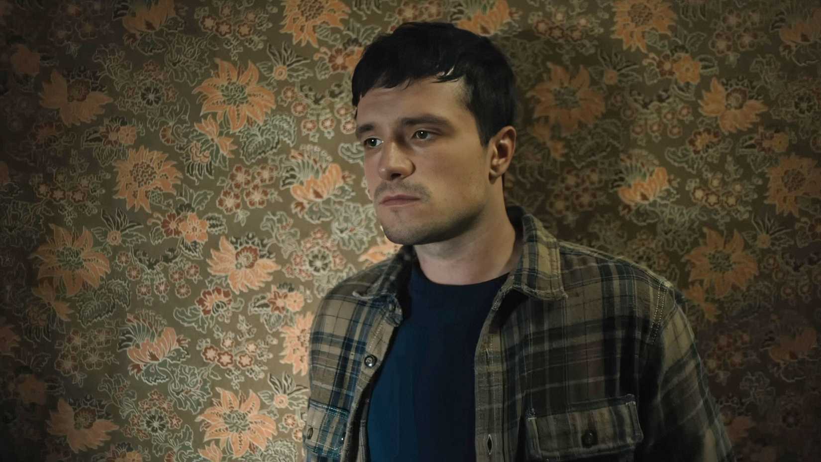 Josh Hutcherson looking bored against floral wallpaper in Five Nights at Freddy's 2
