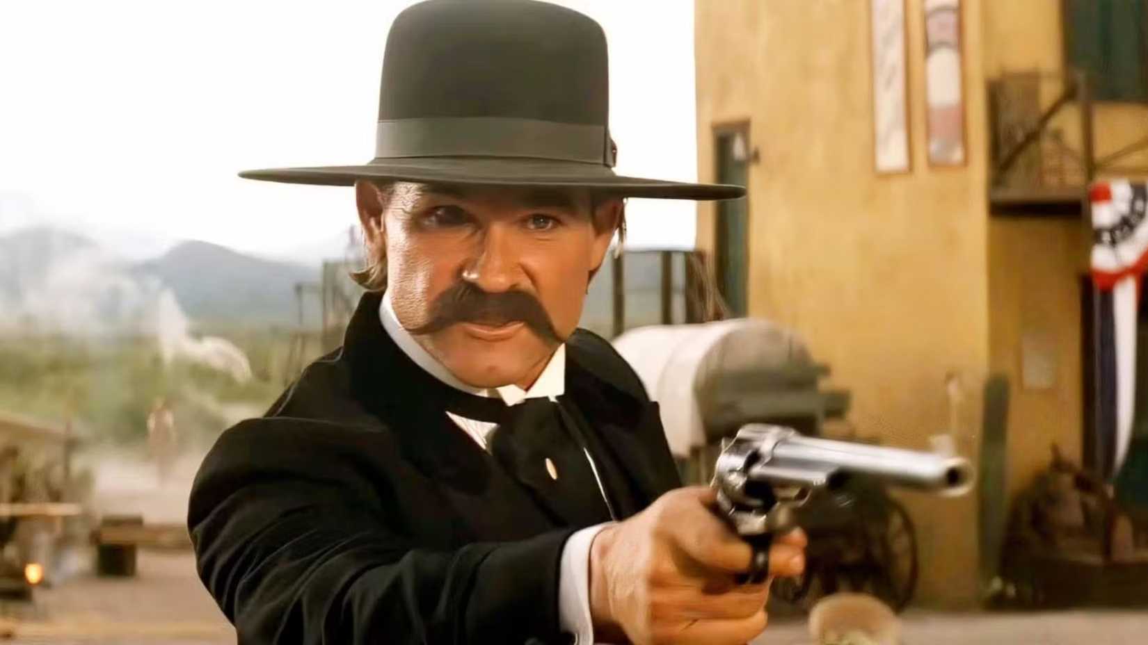 Kurt Russell as Wyatt Warp aiming a gun in Tombstone