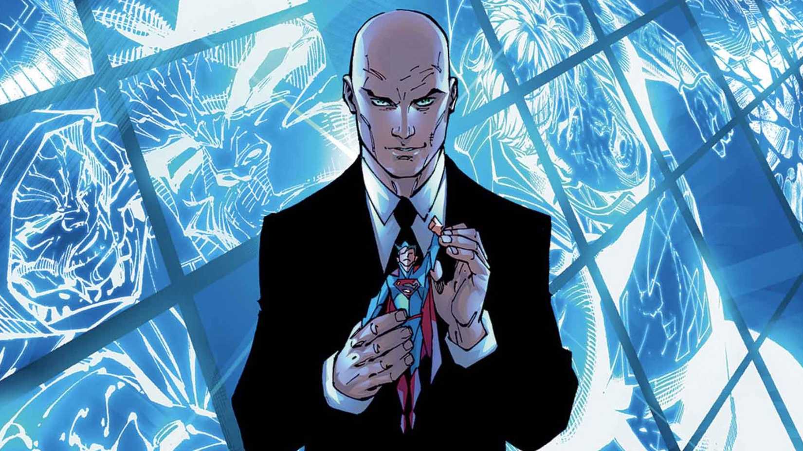 Lex Luthor standing in front of monitors hold a Superman action figure.