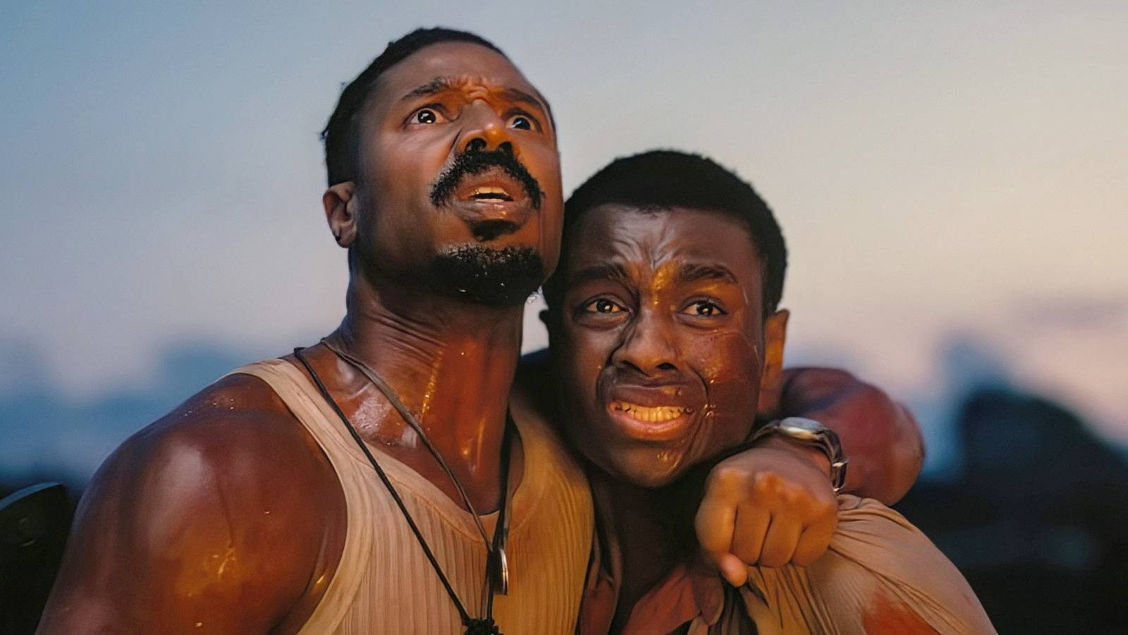 Michael B. Jordan and Miles Caton huddle together in fear in a scene from Sinners