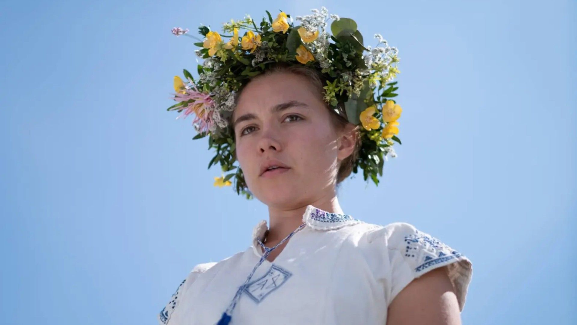 Florence Pugh looks disturbed while wearing a flower crown in Midsommar