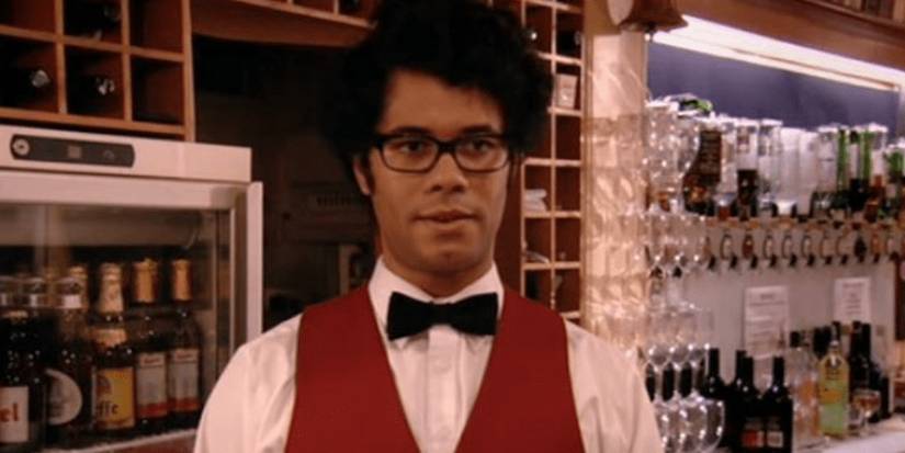 Moss standing behind a bar in The IT Crowd