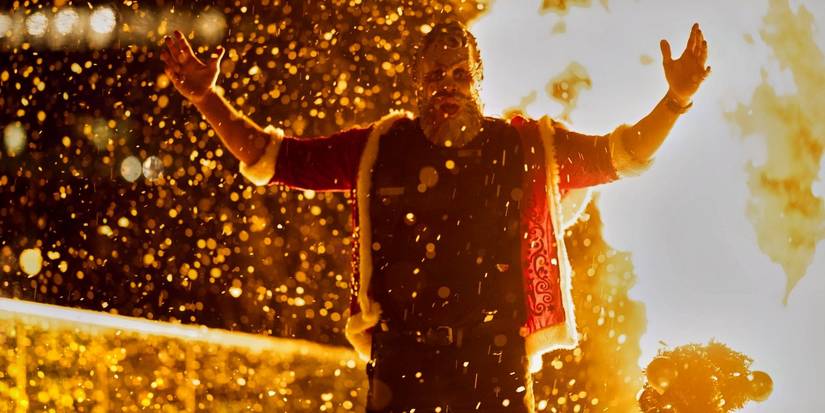 Дед Мороз Паула Джохансона перед горящим рождественским деревом в фильме "Детектив Найт: Возрождение"