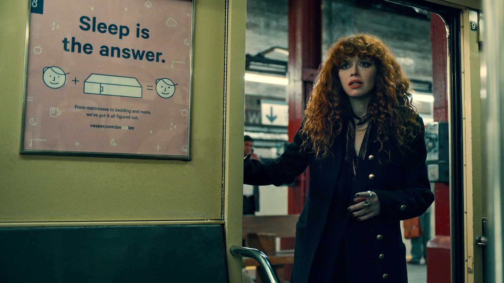 Natasha Lyonne como Nadia em pé no metrô na série Boneca Russa