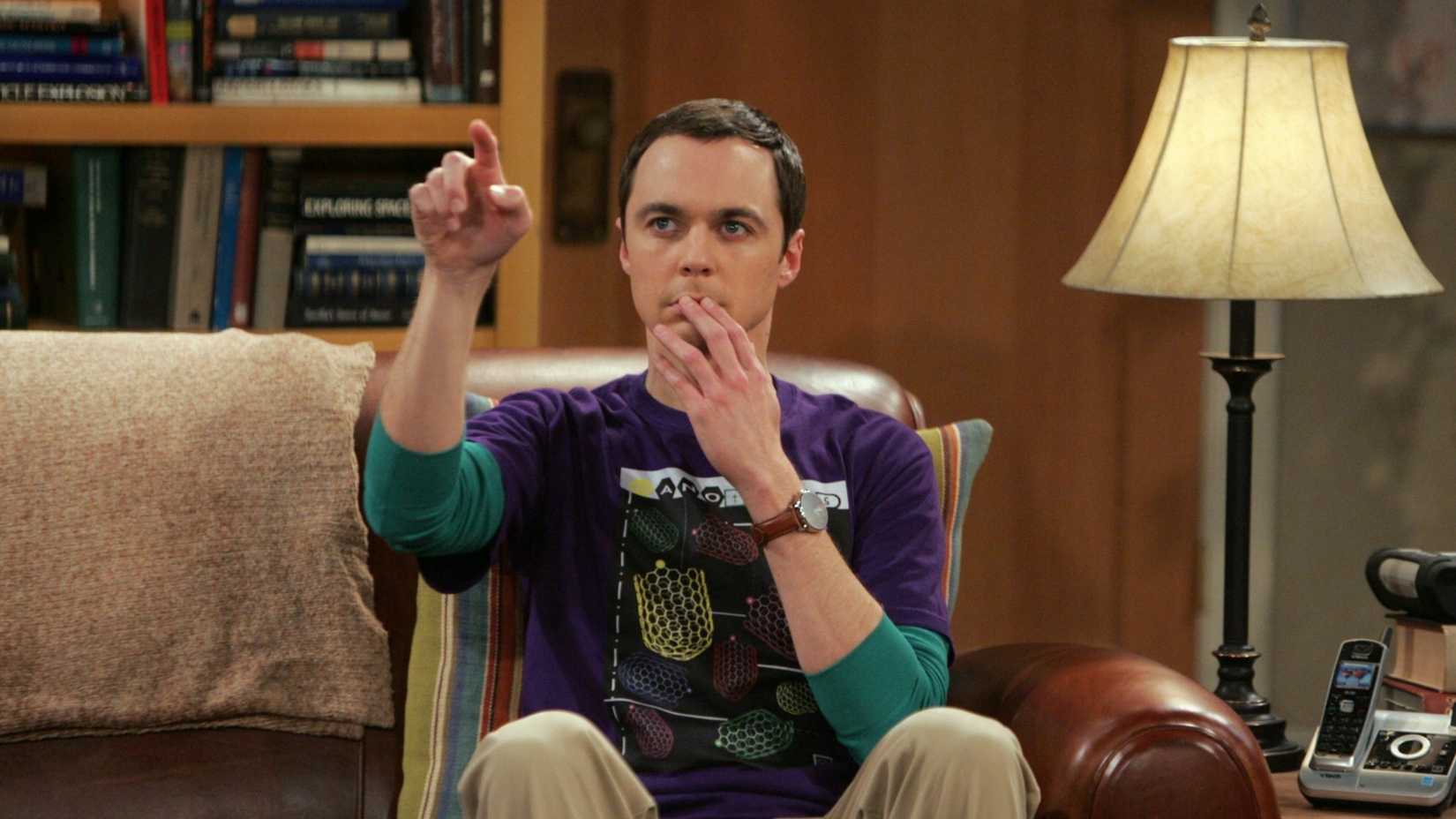 Sheldon Cooper (Jim Parsons) calculando algo em seu lugar no sofá em The Big Bang Theory