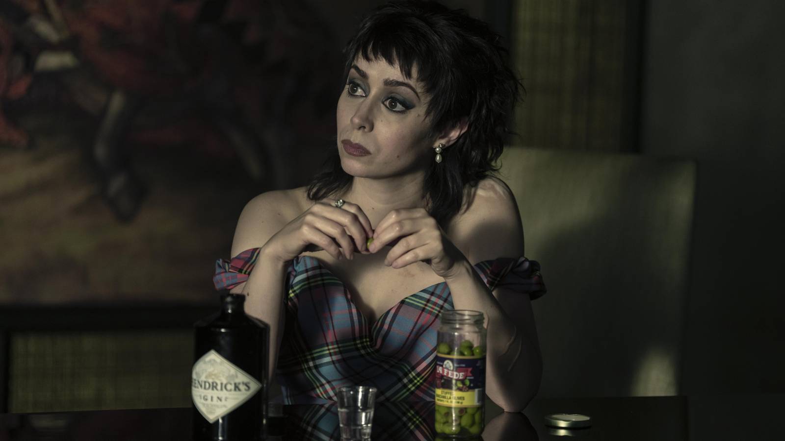 Cristin Milioti Sofia Falcone sitting at a table touching her hands together in The Penguin