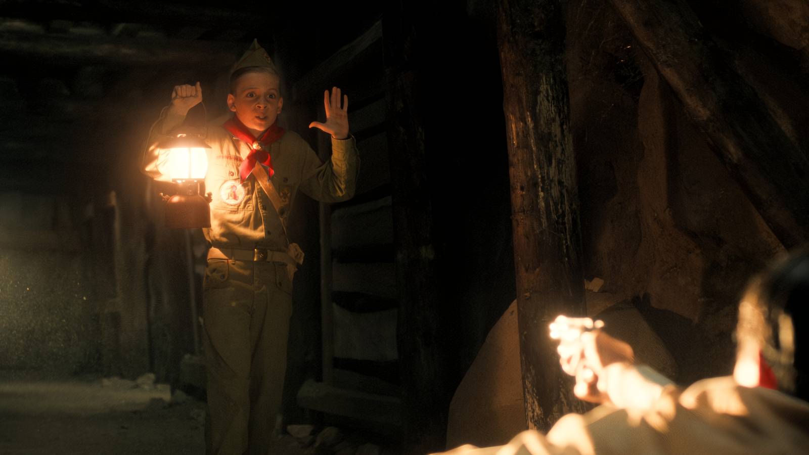 Stranger Things still featuring Young Henry in the cave with a lamp.