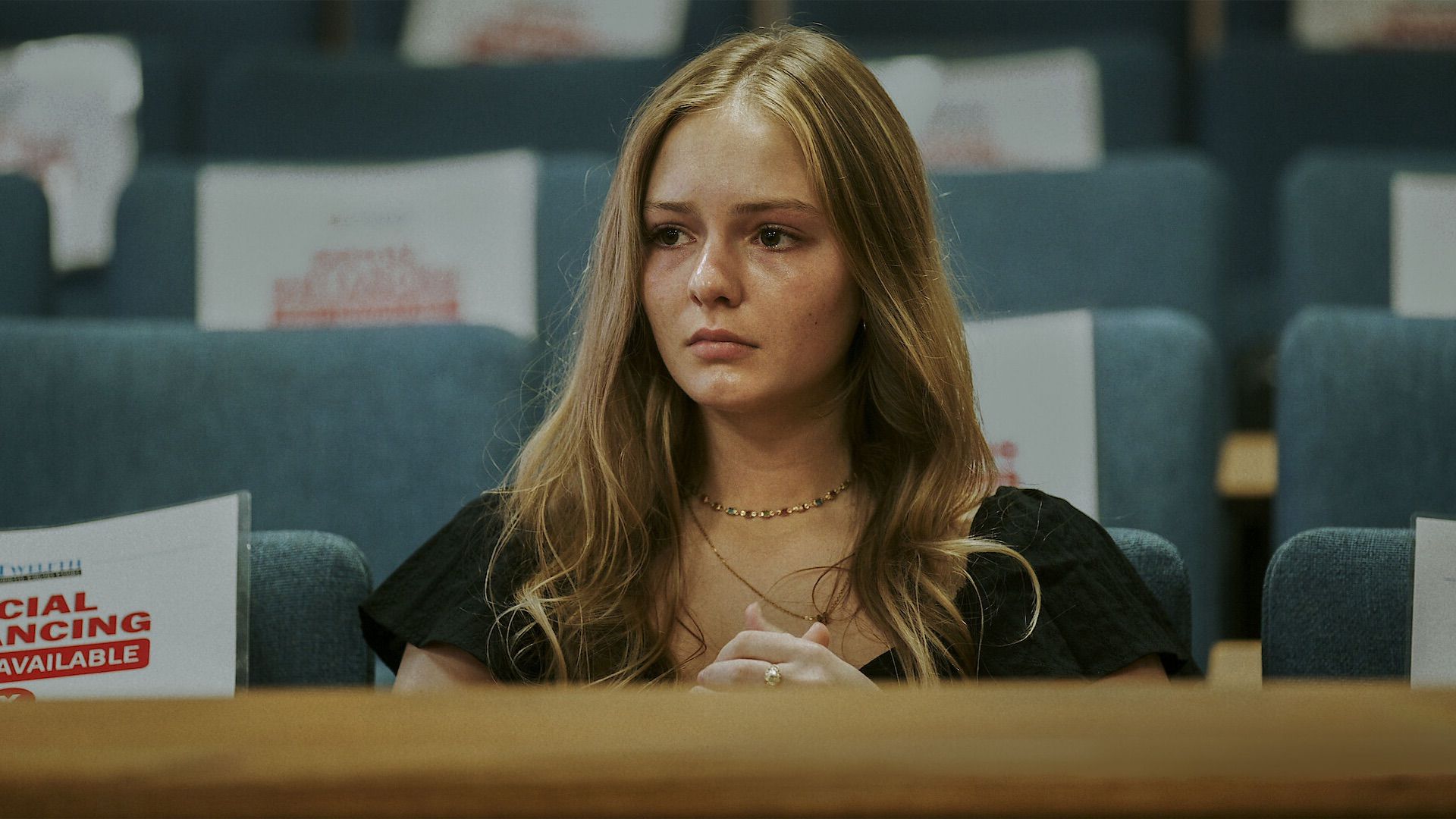 Una giovane donna in tribunale, commossa