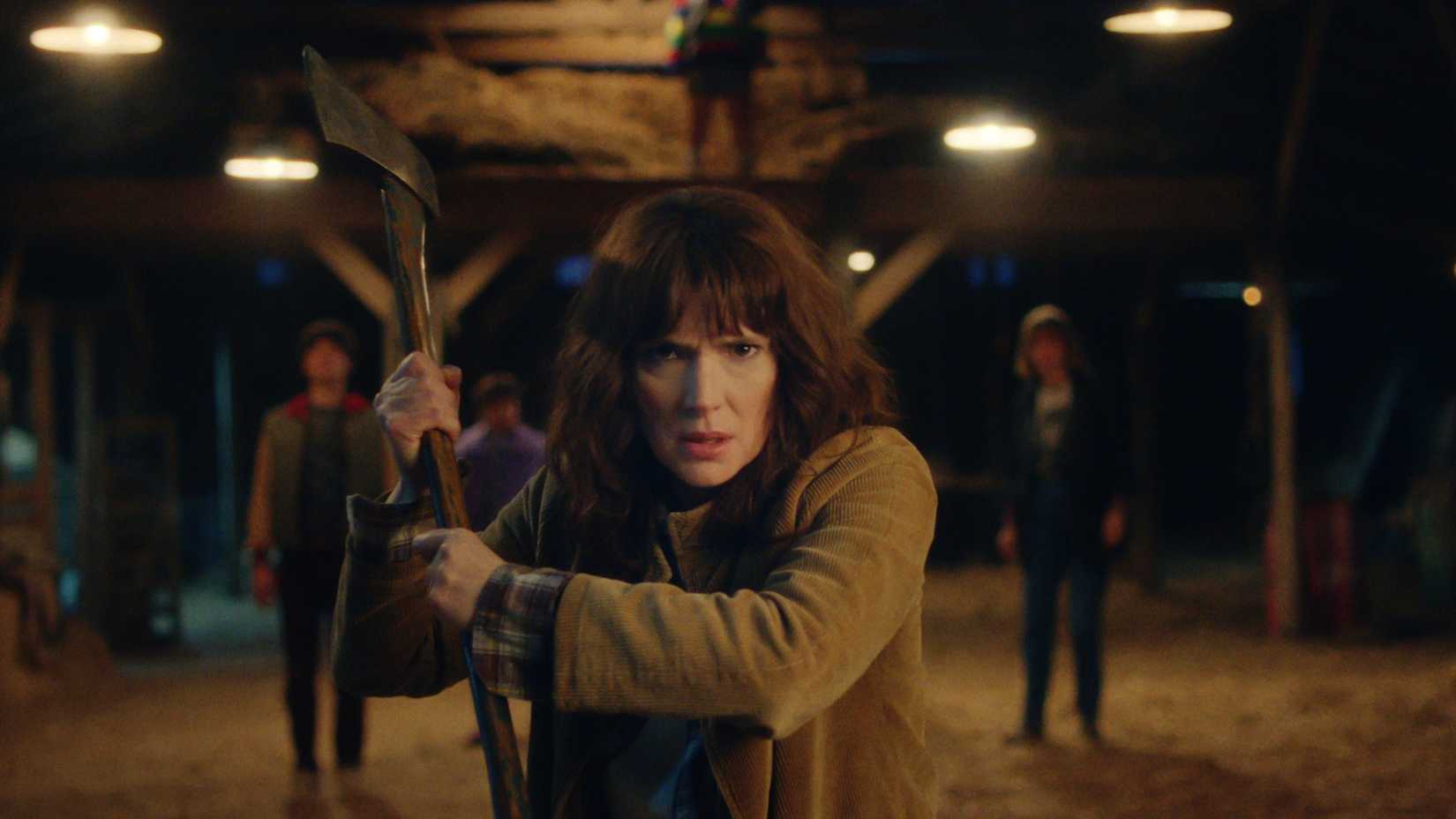 Joyce Byers (Winona Ryder) holding an ax and looking fierce before facing a Demorgorgon in Stranger Things season 5