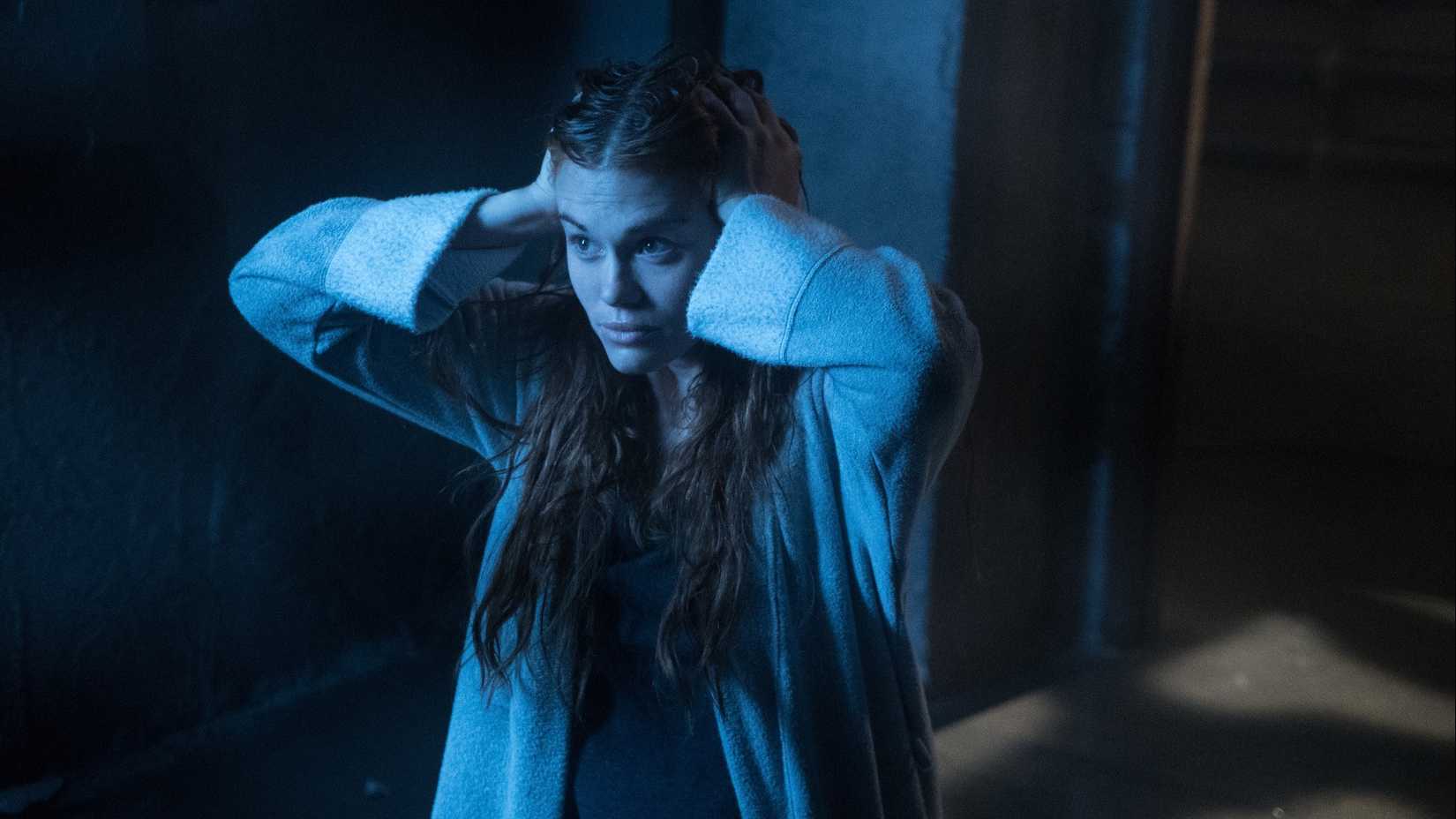 Holland Roden como Lydia Martin, parecendo aflita com as mãos na cabeça na 5ª temporada de Teen Wolf.