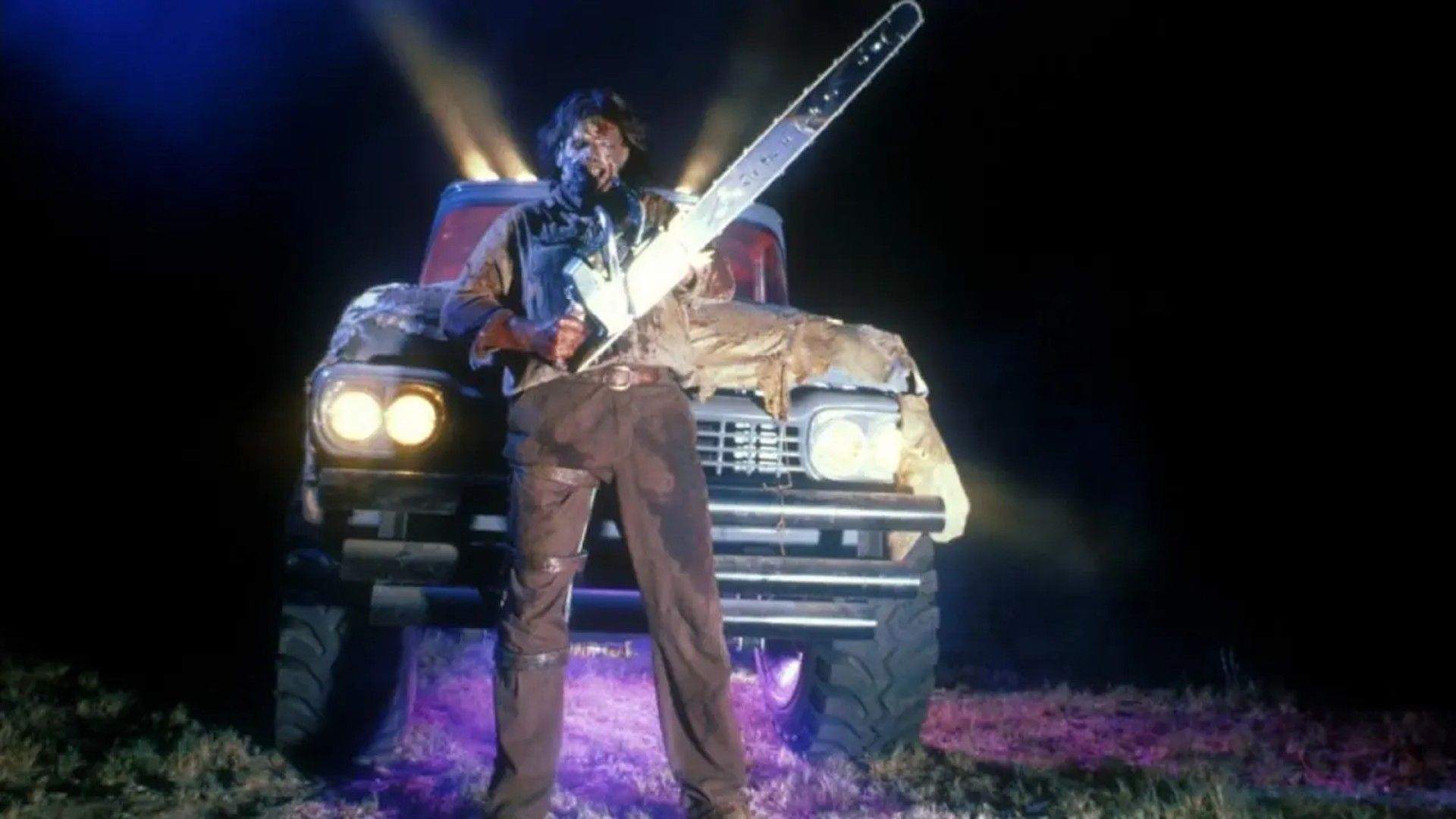 Leatherface con motosega davanti a un camion
