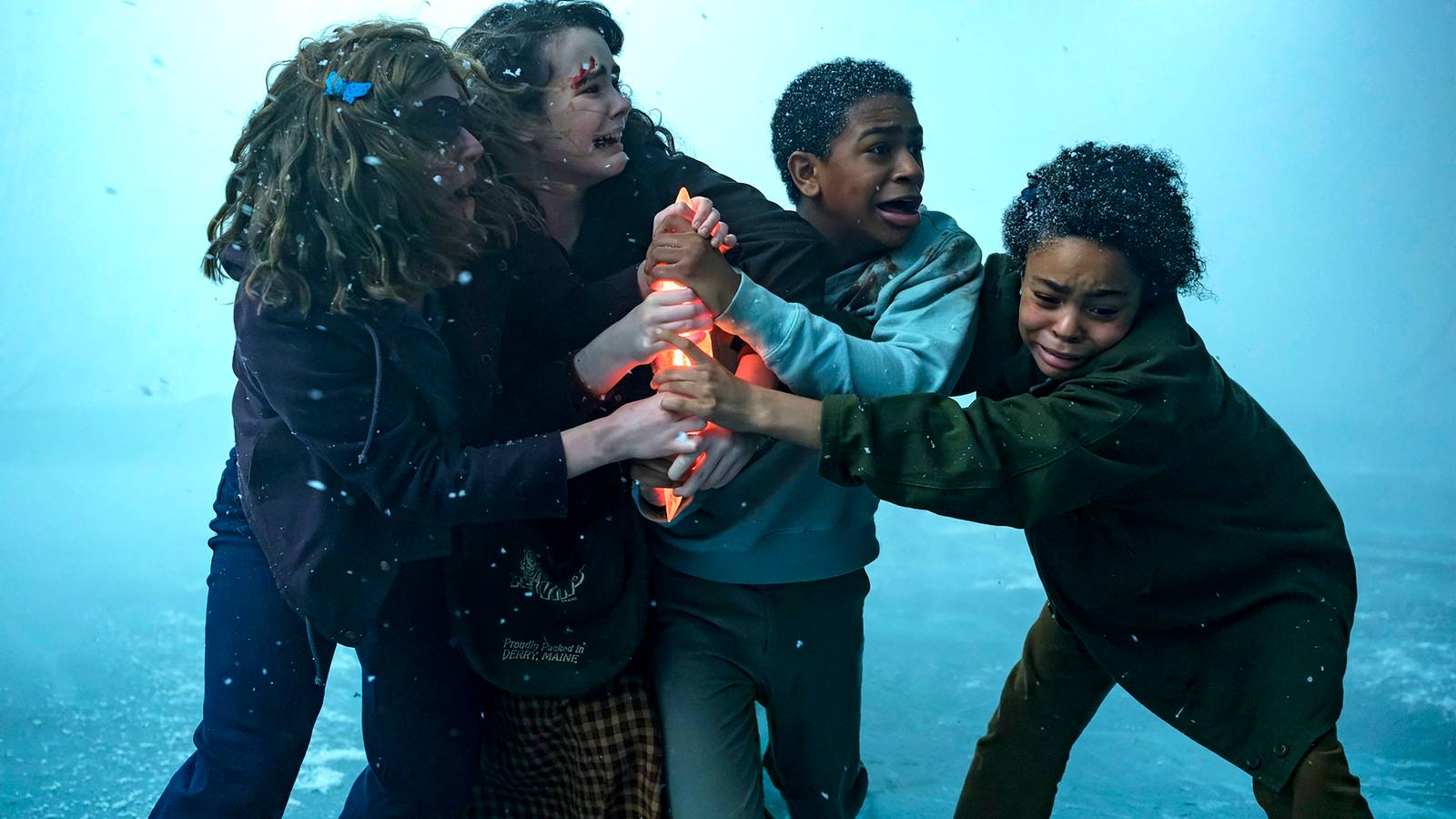 The kid group struggling over the meteor shard on the frozen lake in IT: Welcome to Derry Episode 8