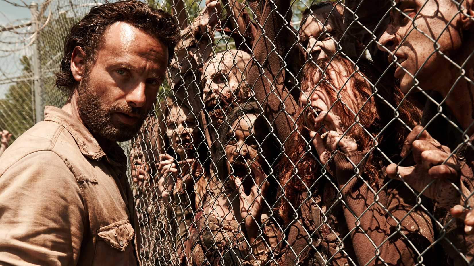 Die Werbeaufnahme von „The Walking Dead“ zeigt Rick vor einem Zaun mit Zombies auf der anderen Seite.