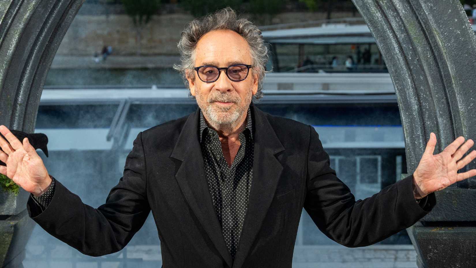 Tim Burton with his arms held apart