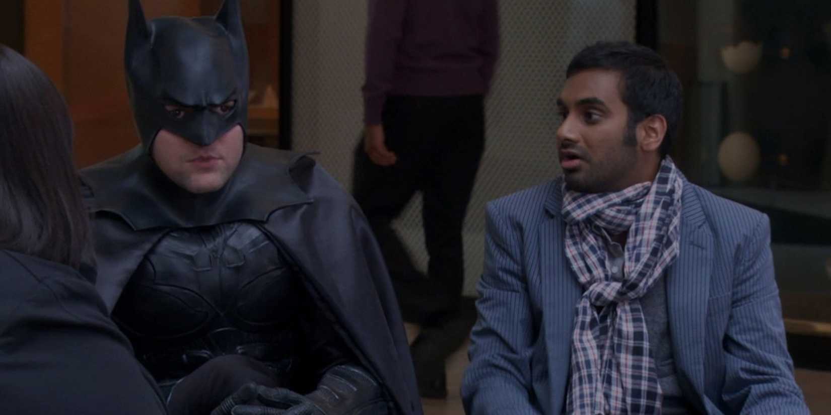 Tom senta ao lado de Ben em um traje de Batman em Parks and Recreation