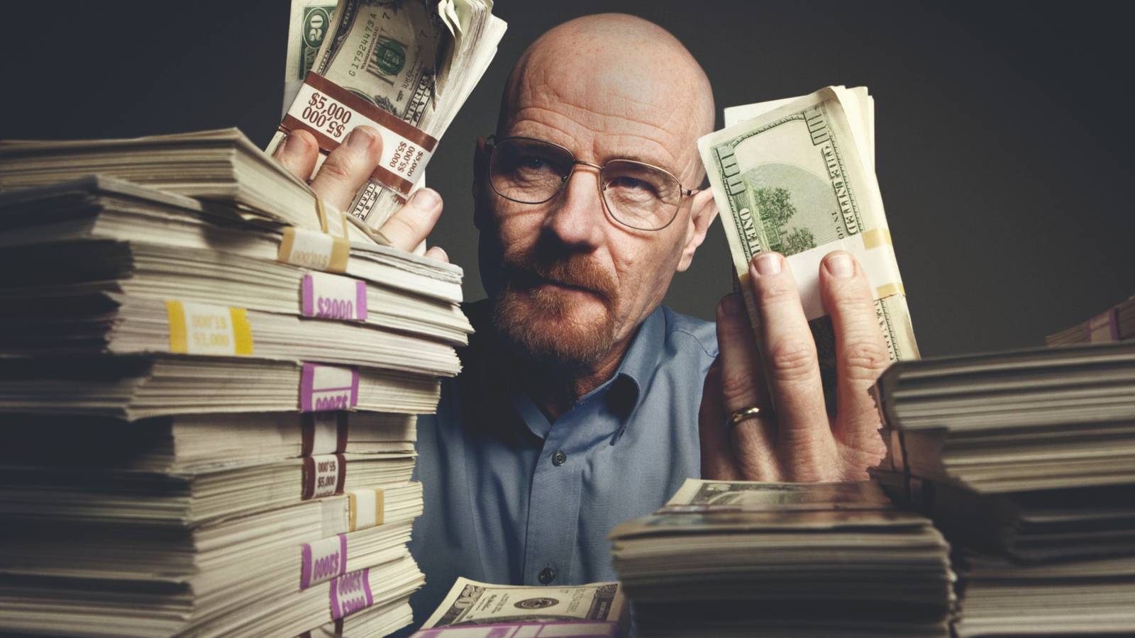 Walter White (Bryan Cranston) holding up and surrounded by stacks of cash in Breaking Bad season 3