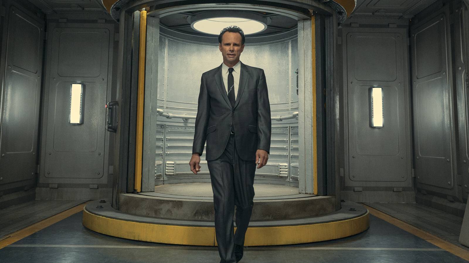Walton Goggins as Cooper Howard wearing a suit and walking towards the camera in Fallout