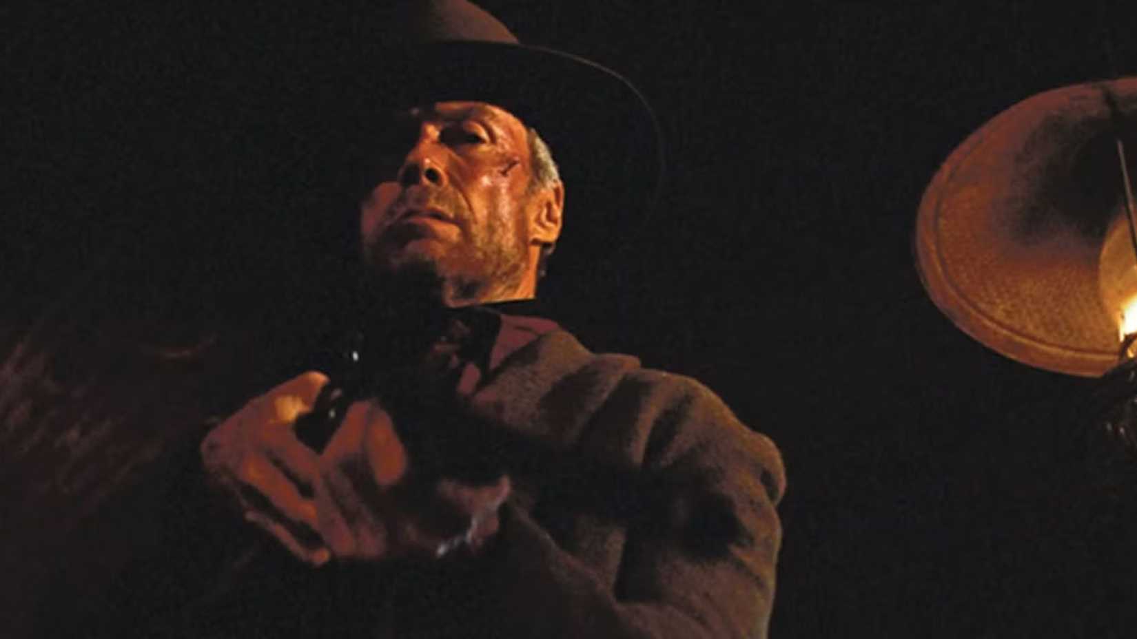 Will Munny mirando um rifle para Little Bill em Unforgiven.