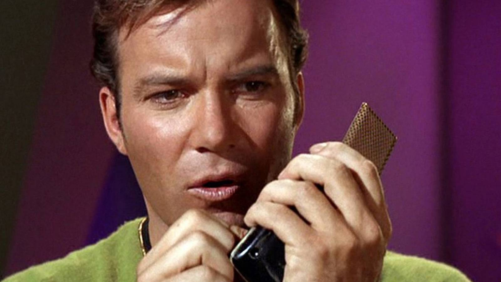 William Shatner as Captain Kirk using a communicator in Star Trek: The Original Series
