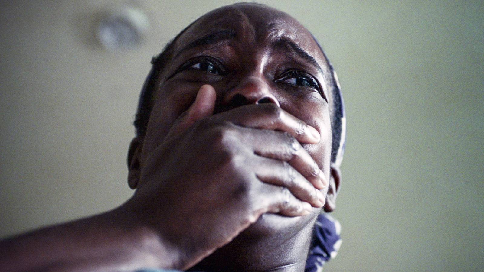 Wunmi Mosaku shot from below covering her mouth in horror in His House