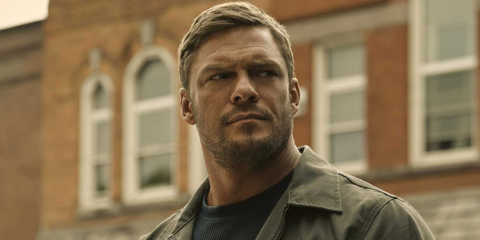 Alan Ritchson como Jack Reacher com expressão confiante.