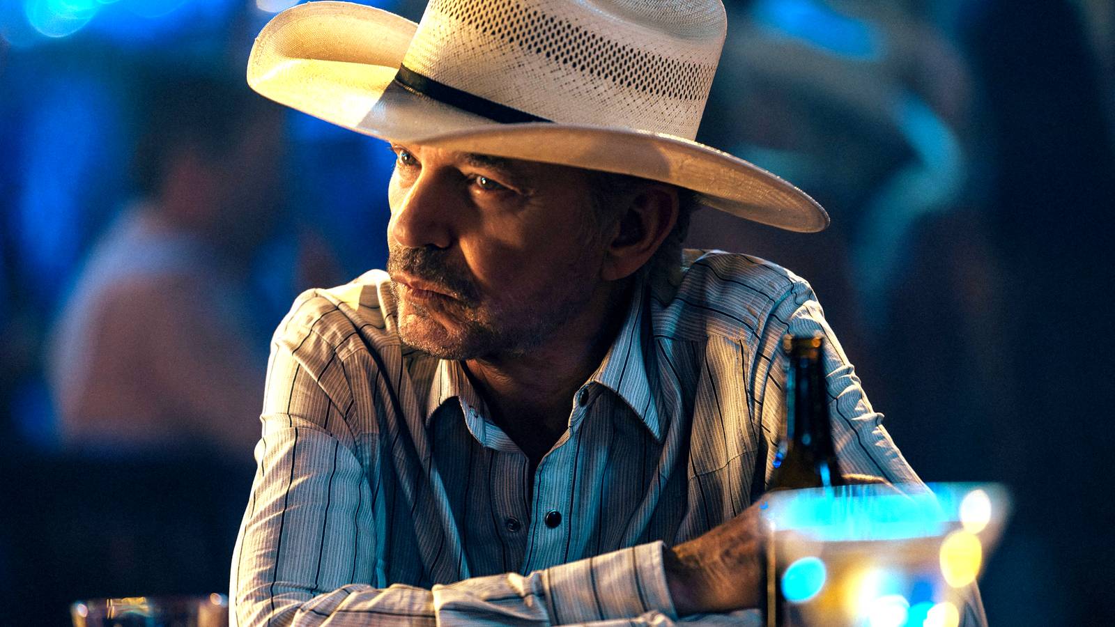 Billy Bob Thornton's Tommy looking in thought while at a bar in Landman season 2