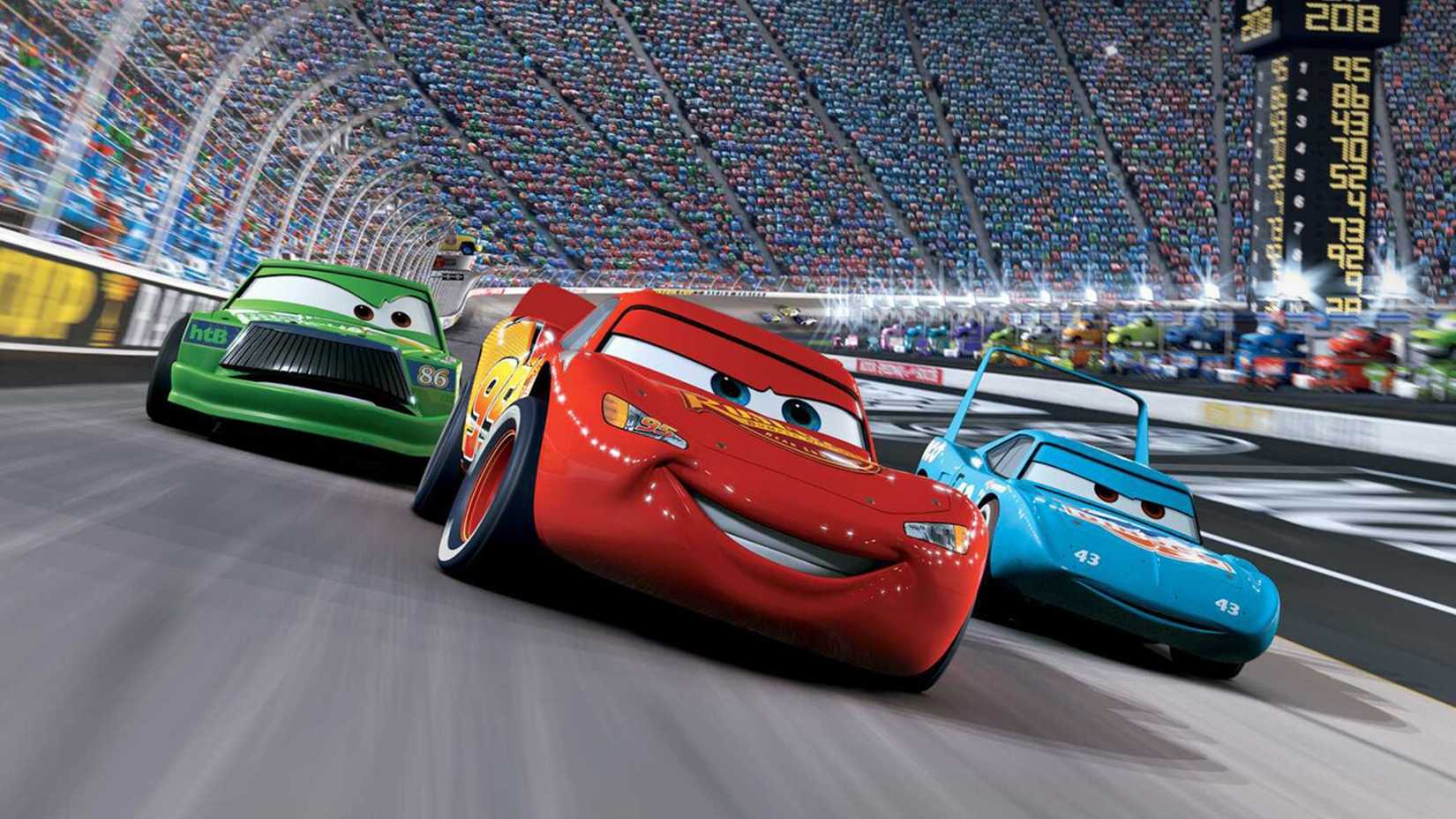 Lightning McQueen smiles as he passes two other cars on the track in Cars