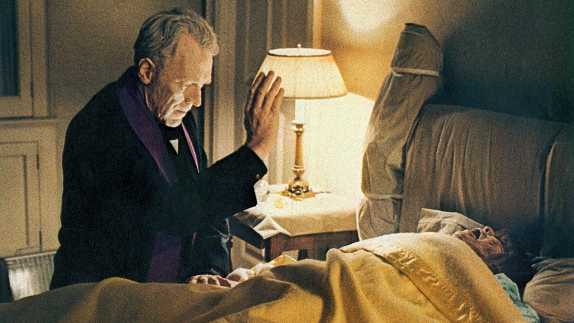 Father Merrin blessing a possessed Regan in The Exorcist
