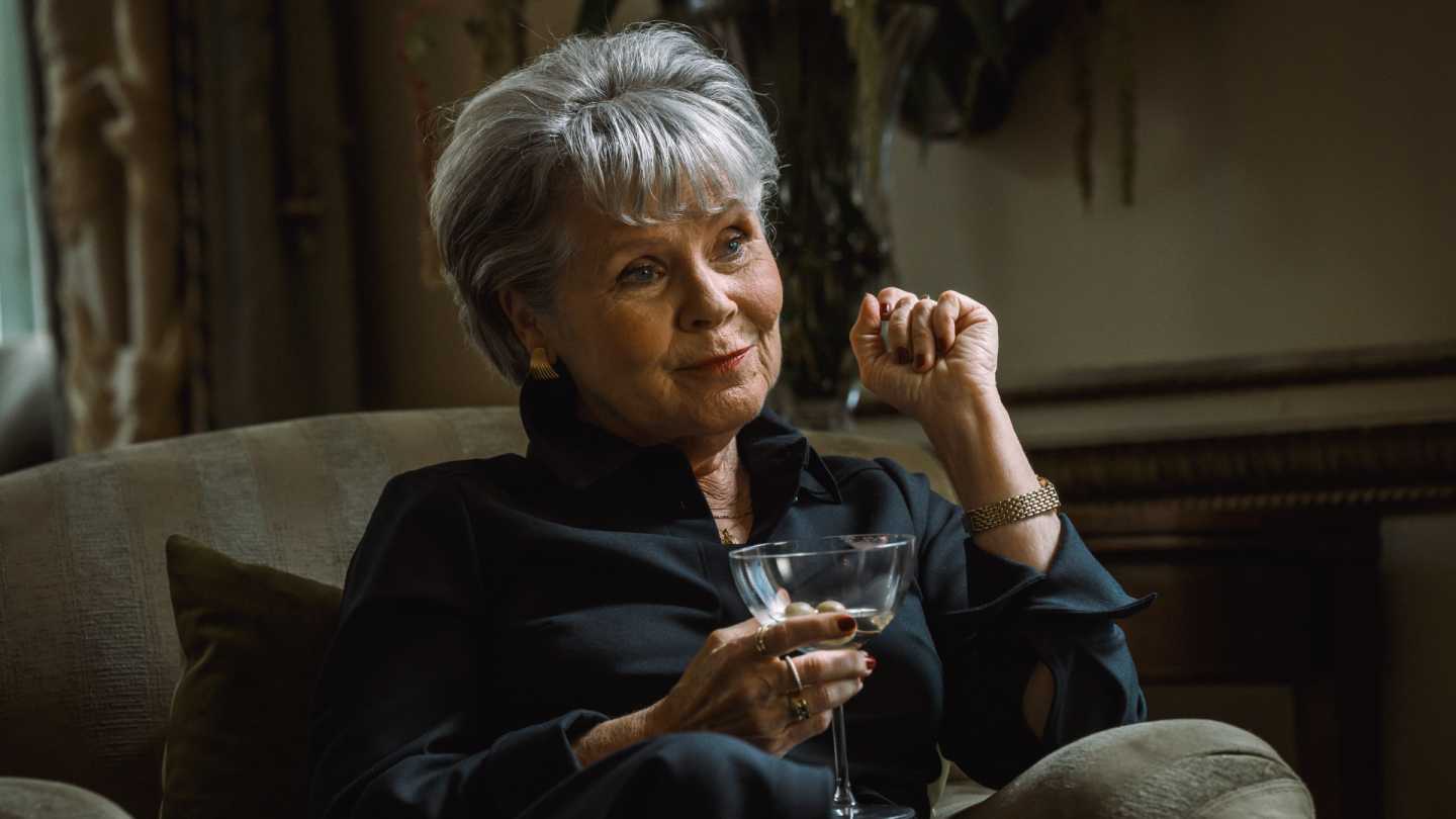 Aunt Ada (Imelda Staunton) holding a martini in Agatha Christie's Tommy & Tuppence
