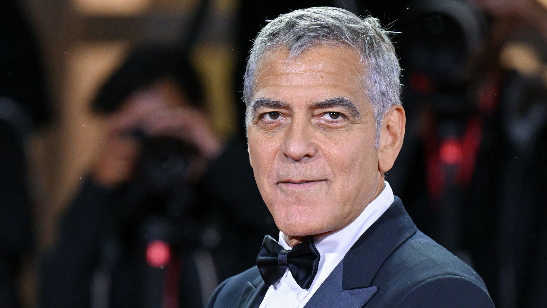 George Clooney looks to the left with a neutral expression while attending an event