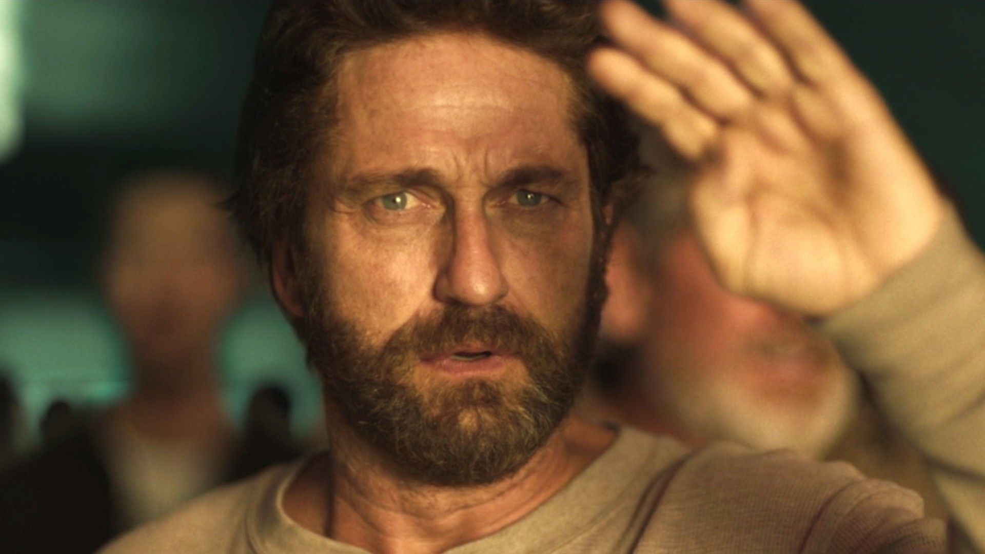 Gerard Butler with his hand up to cover the sun's rays in Greenland