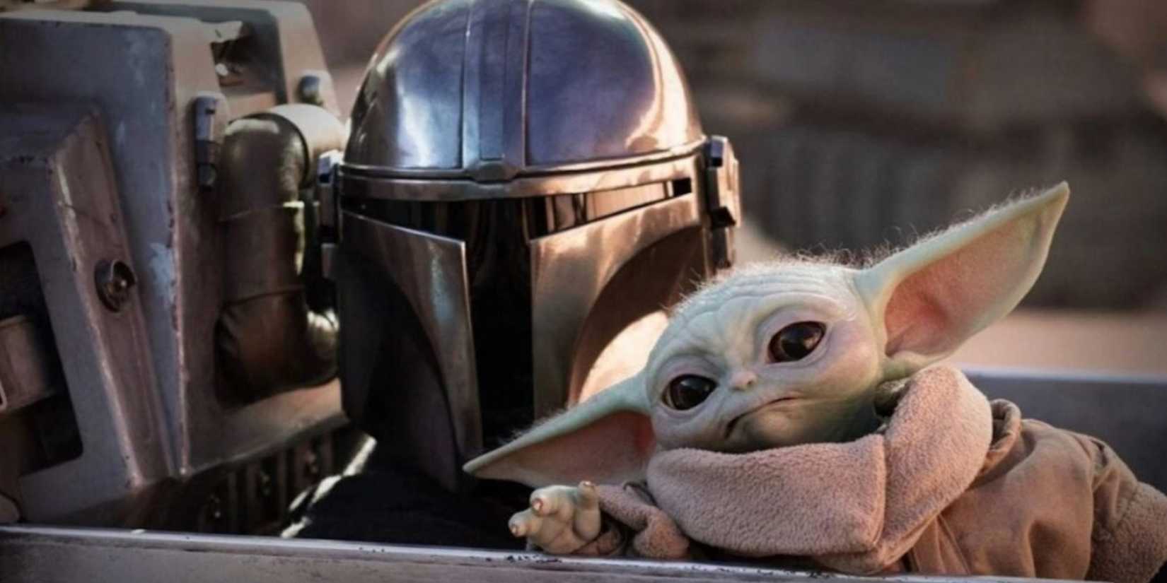 Grogu and Din Djarin peering over the edge of a ship's cockpit